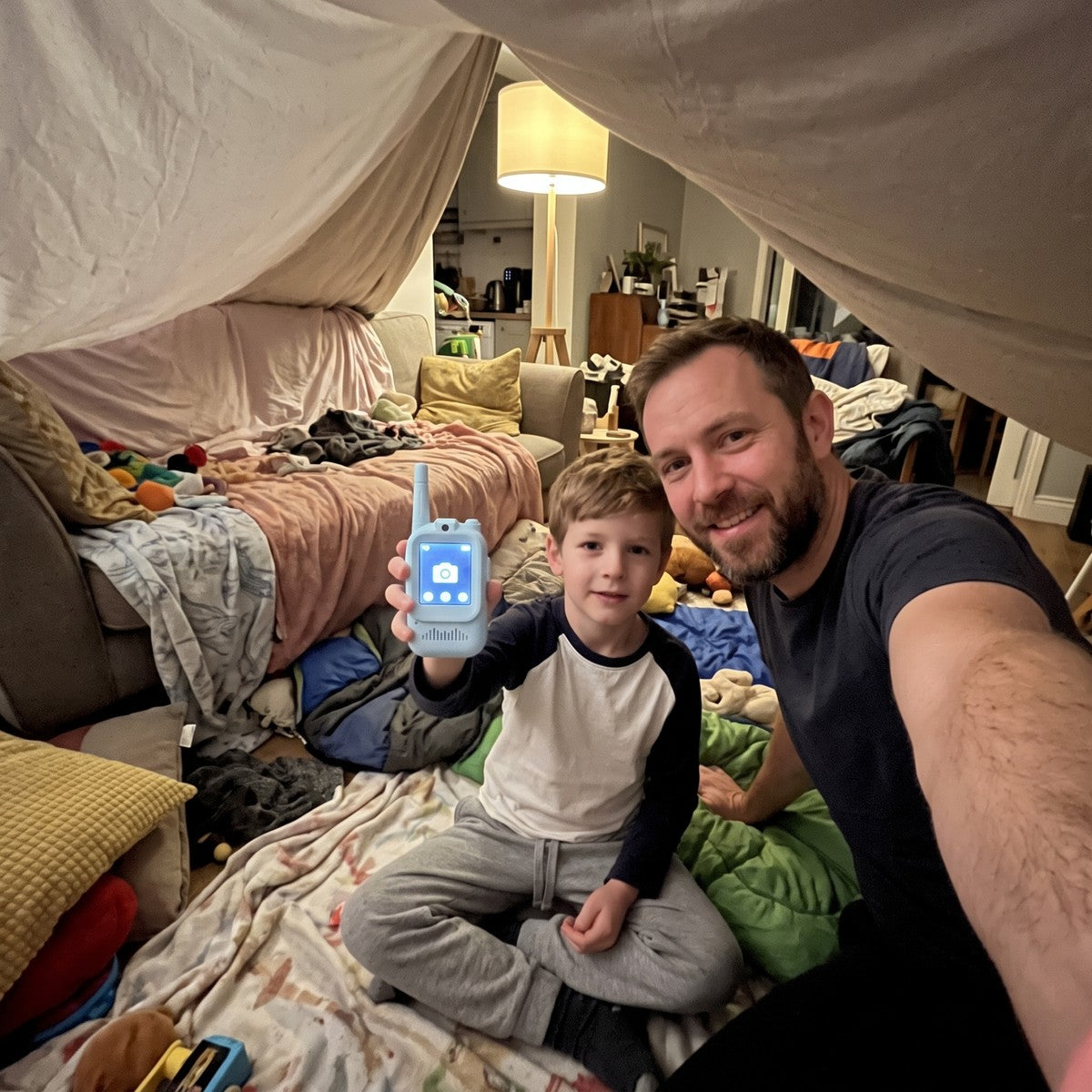 Dad’s selfie with child using blue Playpal beside an indoor tent